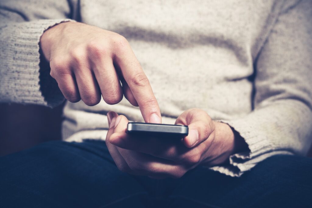 man browsing through Google's Carousel using a mobile phone