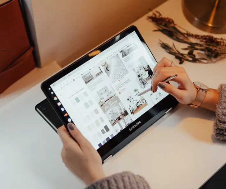 woman doing a shopping website layout using Shopify through a tablet