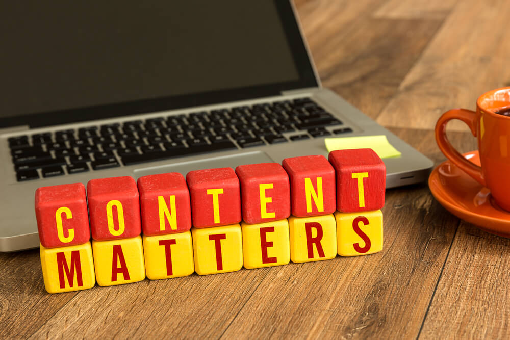 Content Matters on red and yellow wooden cubes in front of a laptop