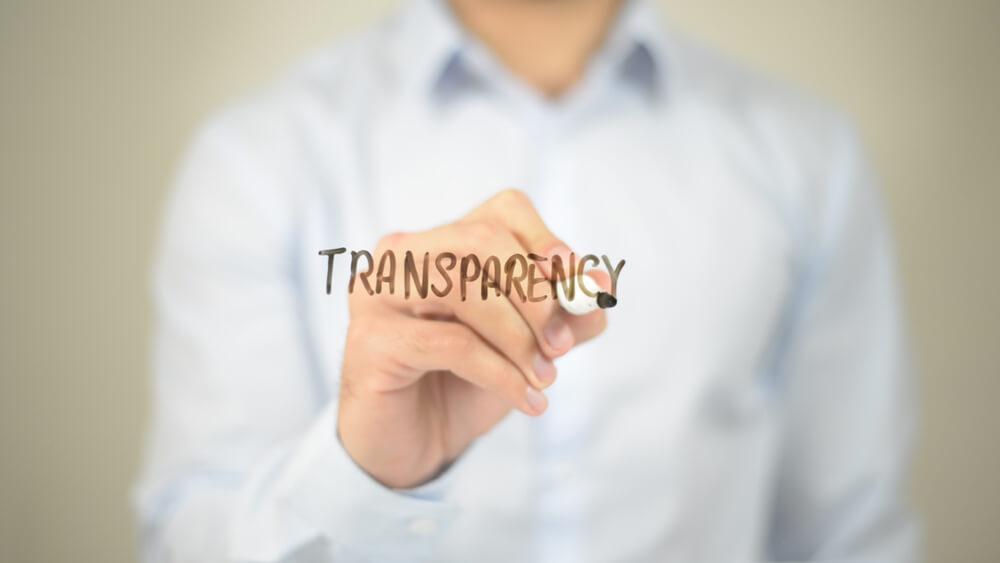 man writing “transparency” on transparent screen