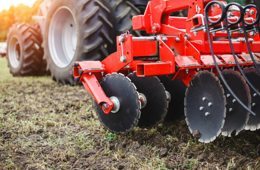 Red tractor on an agricultural field close up image