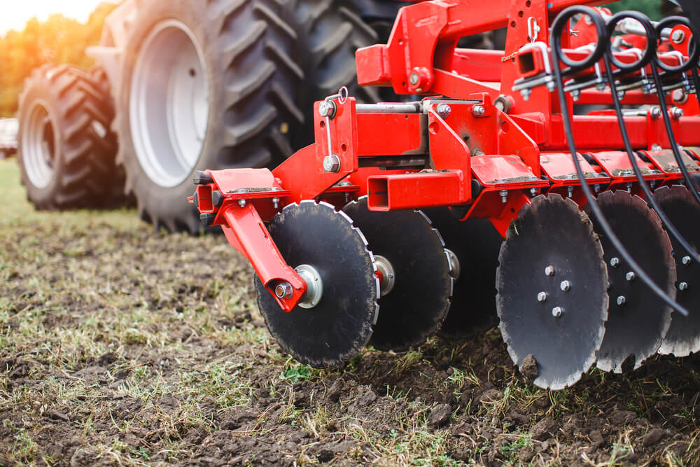 Red tractor on an agricultural field close up image