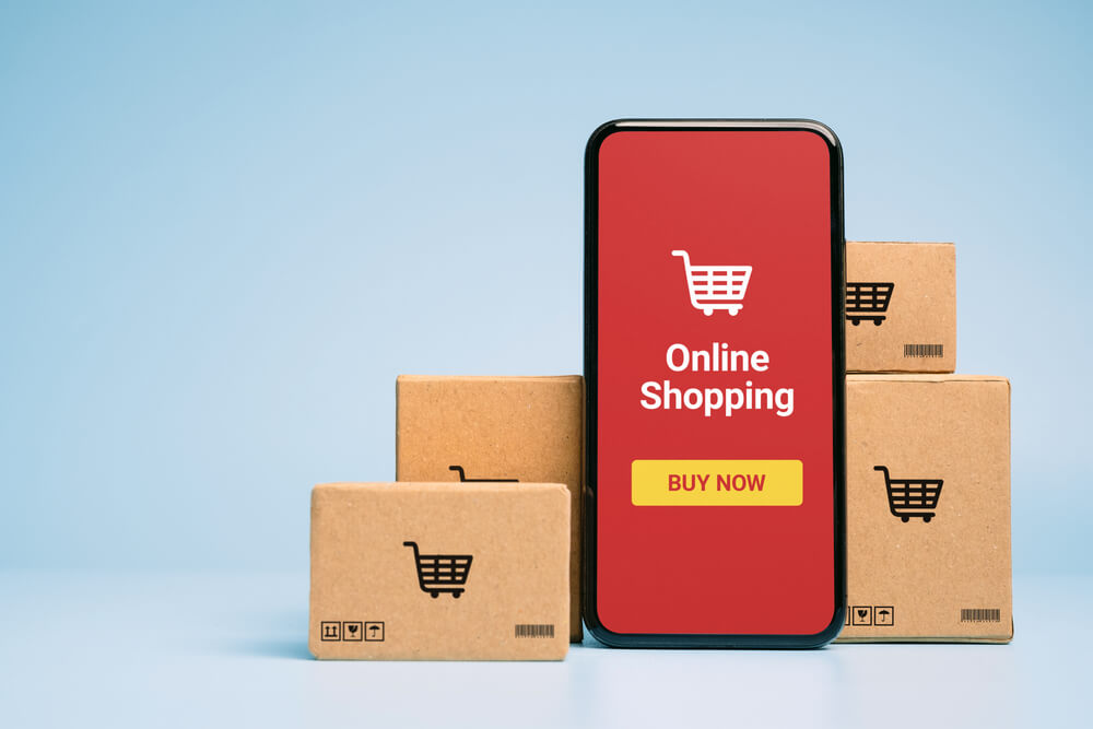 smartphone showing online shopping supported by small boxes
