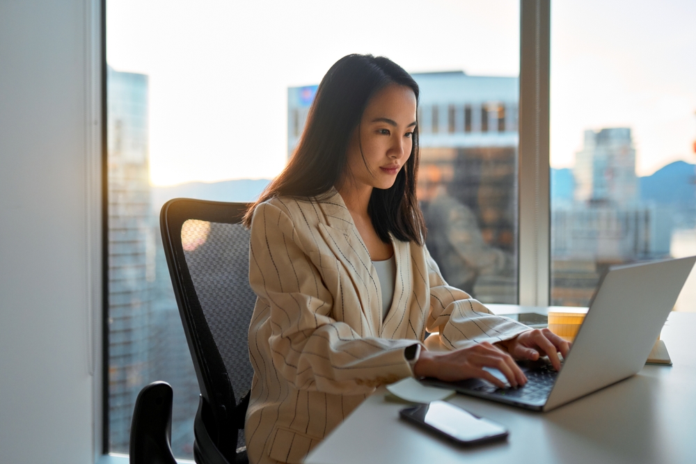 Busy,Asian,Business,Woman,Using,Laptop,In,Company,Office.,Young
